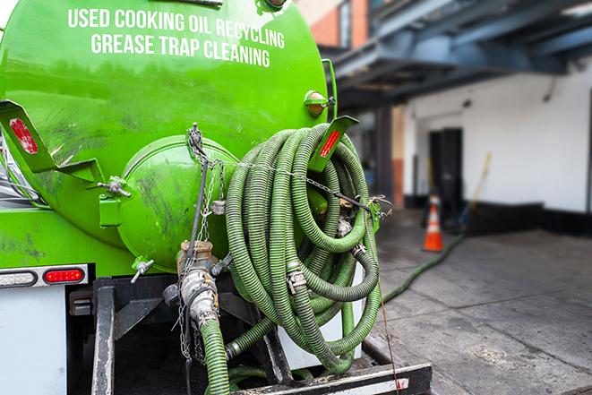 a technician pumping a grease trap in a commercial building in Perrysville